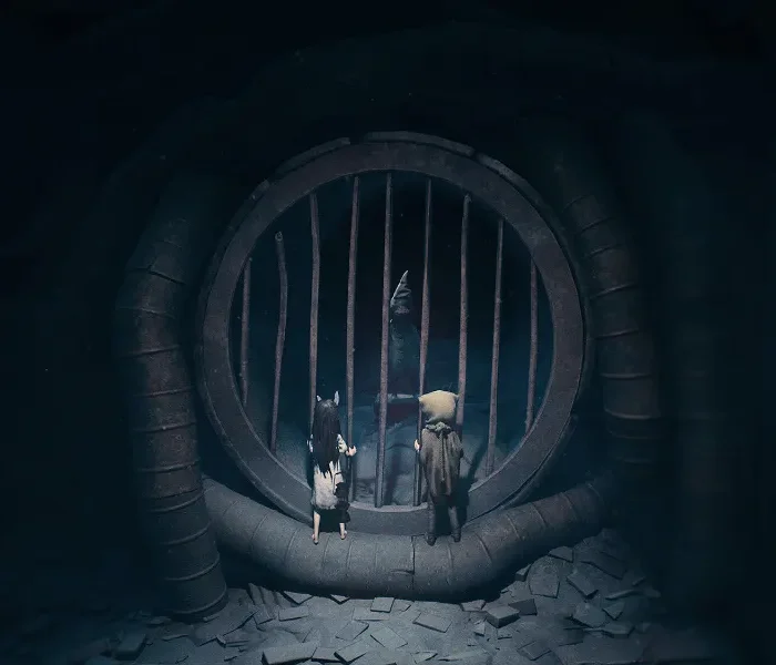 Captura del juego Reanimal en Steam mostrando a los dos protagonistas ante una reja en un entorno oscuro.